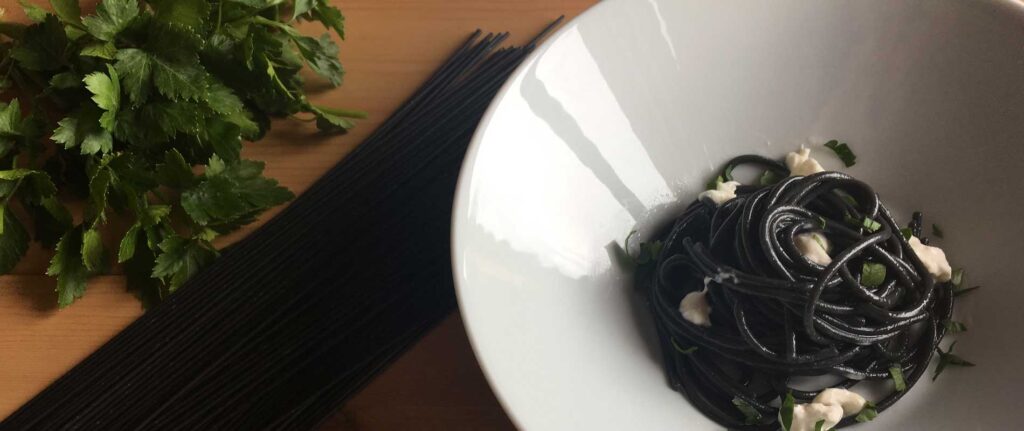 Spaghetti neri con colatura di alici e fiocchi di stracciatella
